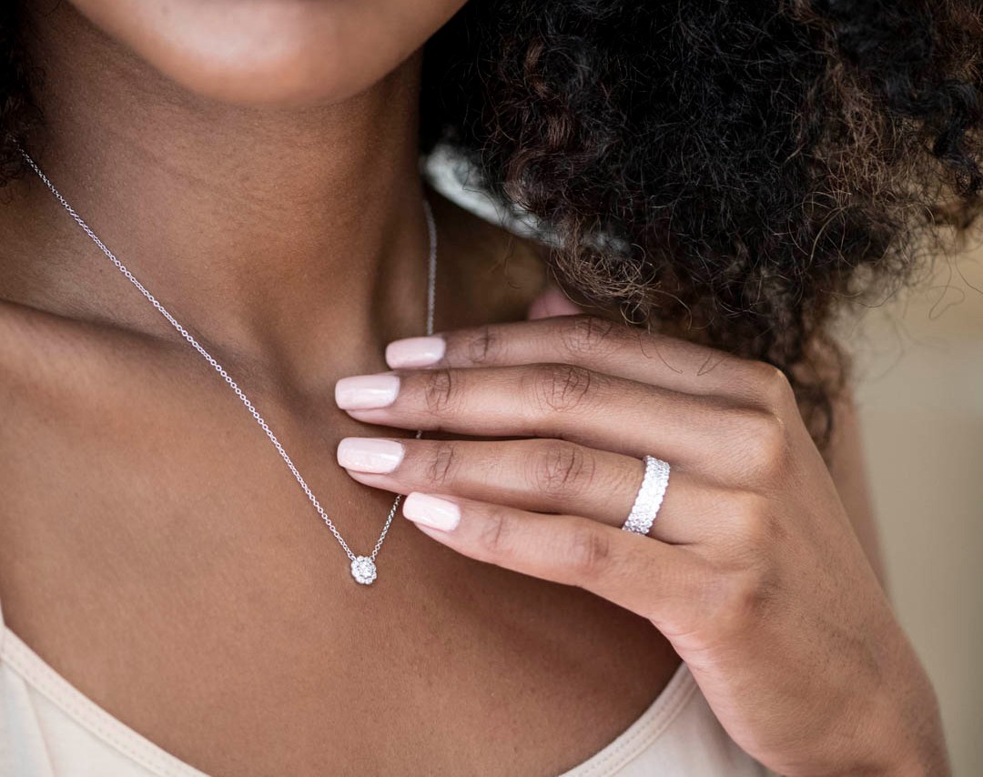 A woman wearing a diamond necklace and ring by Hearts On Fire