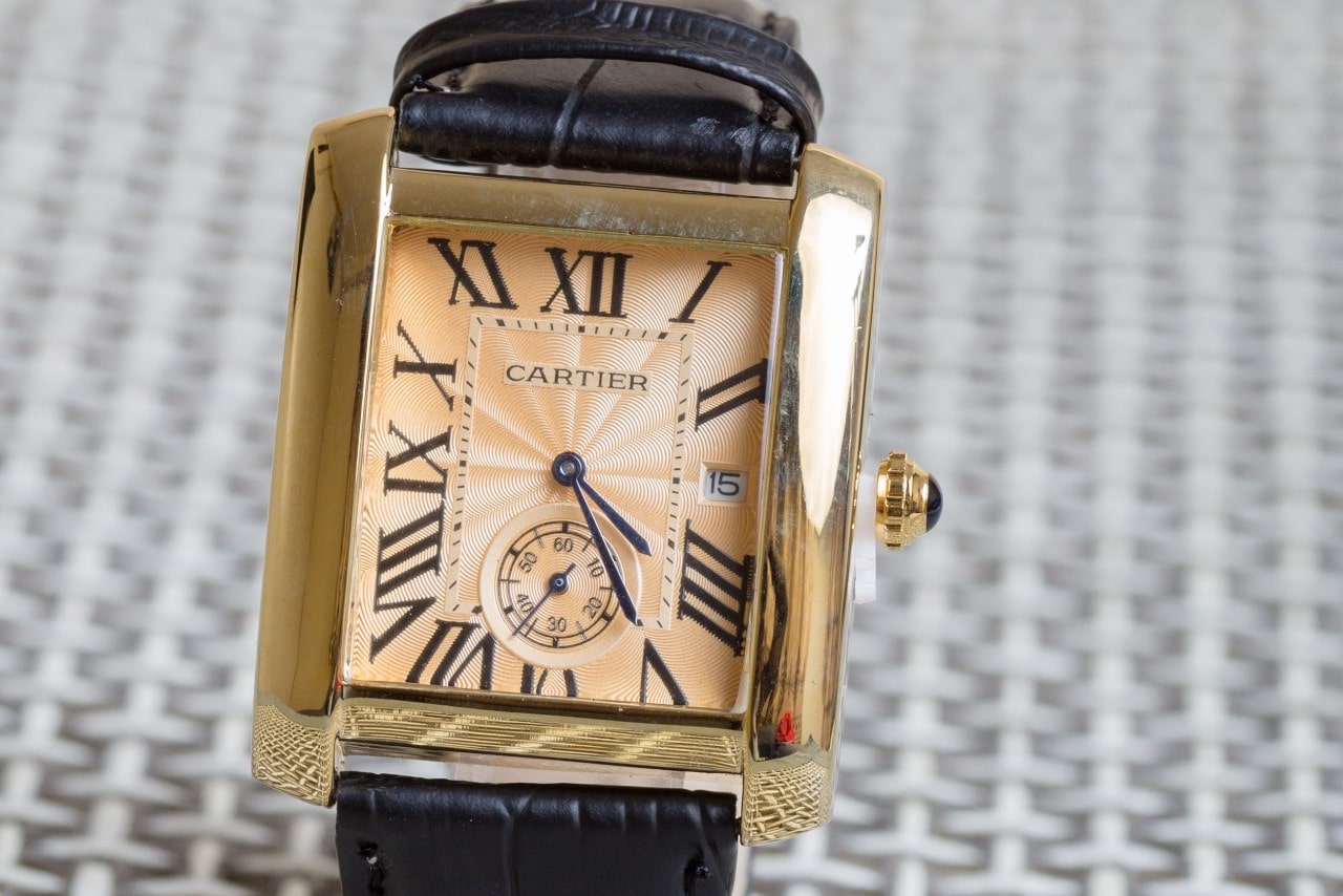 close up image of a yellow gold Cartier Tank watch