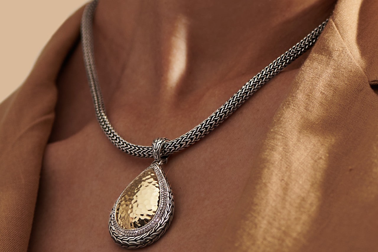close up image of a person&rsquo;s neckline wearing a chunky chain pendant necklace from John Hardy