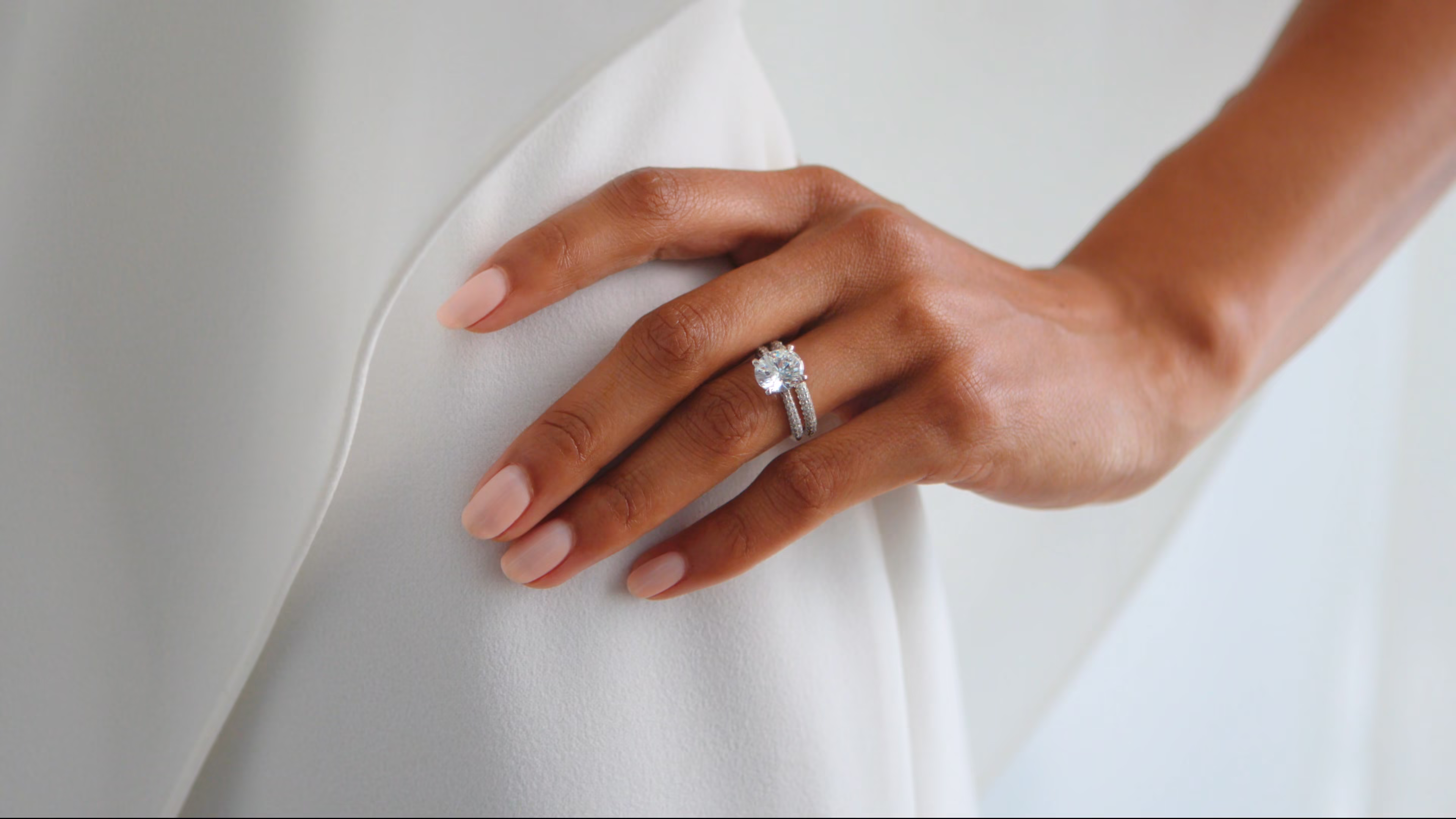 Woman wearing a wedding ring on her ring finger. Hand is on her hip.